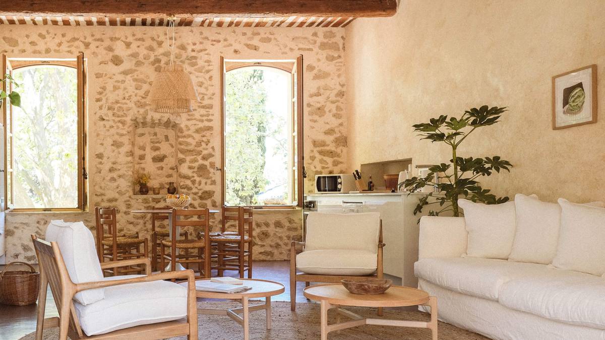 A well-organized living space features a cozy sofa, round coffee table, plant, and dining set.