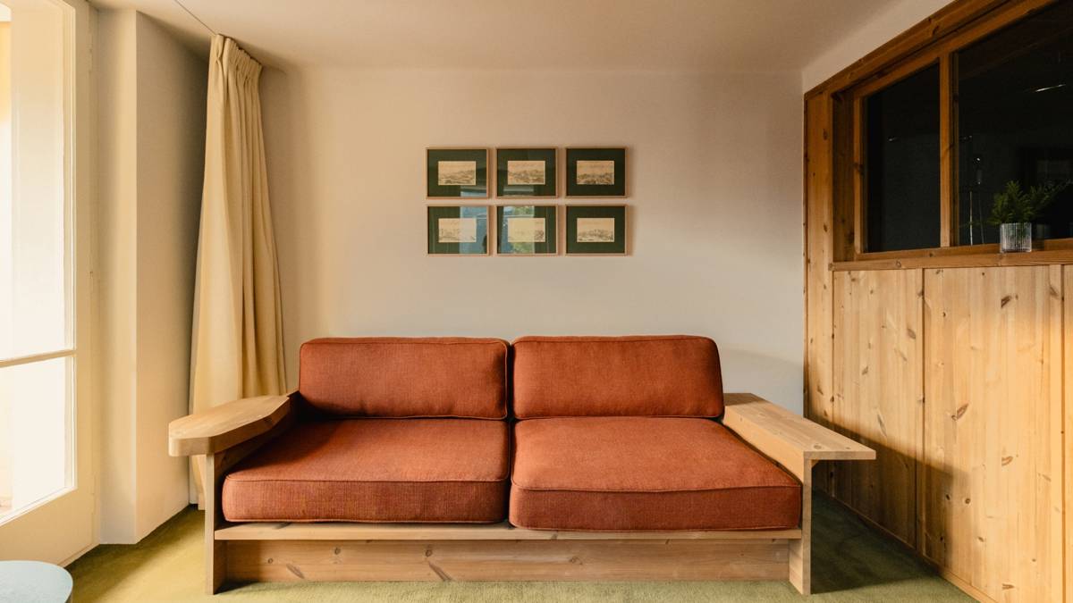 A cozy sofa is placed near the wall, with several portraits mounted above it.