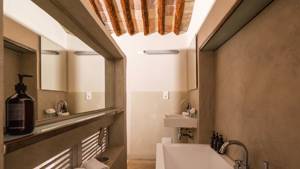 A neatly arranged bathroom features organized bathing essentials and a bathtub positioned in the corner.