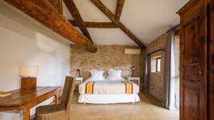 A well-organized bedroom features a bed with side tables holding lamps and a nearby chair.