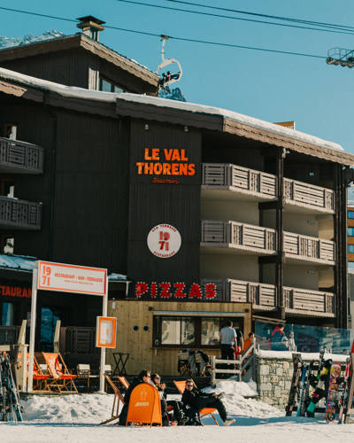 Restaurant Le Val Thorens avec porte-skis, terrasse et skieurs au dehors