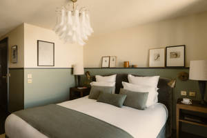 Chambre du Fitz Roy avec photographies de ski vintage, murs vert sauge et lustre en Murano