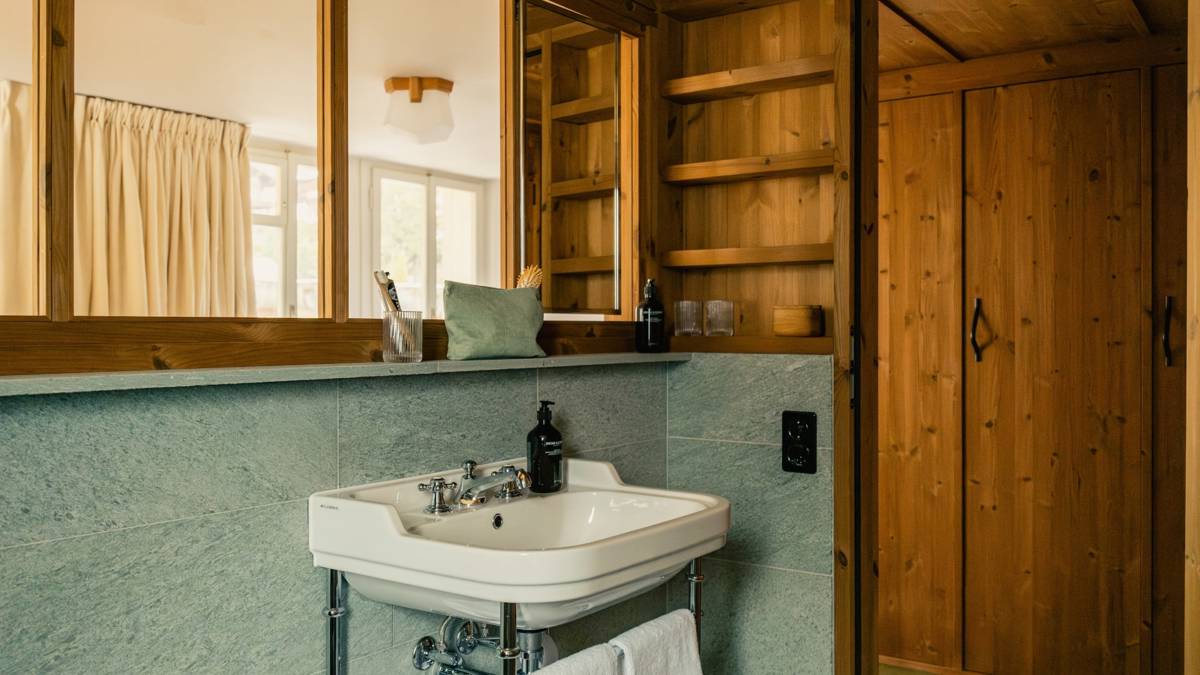 A large mirror is mounted above the washbasin in the bathroom, beautifully reflecting the space.