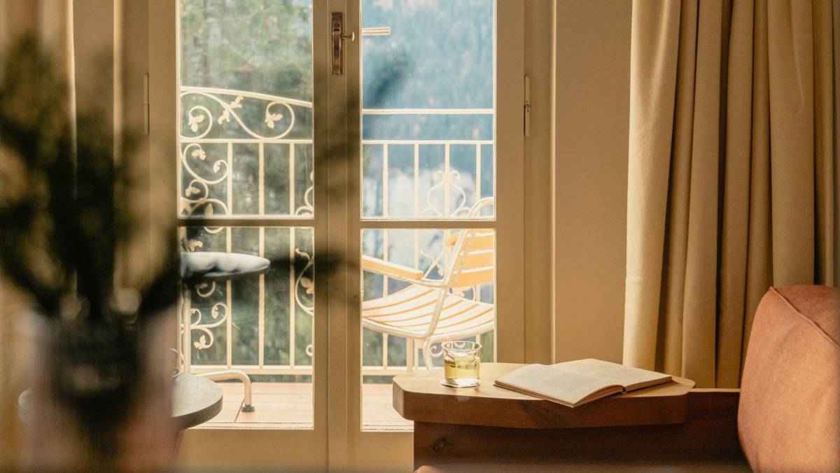 A cozy sofa is placed near the large glass door, offering a wonderful outside view.