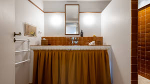 A clicked photo of the bathroom shows a long mirror mounted above the washbasin.