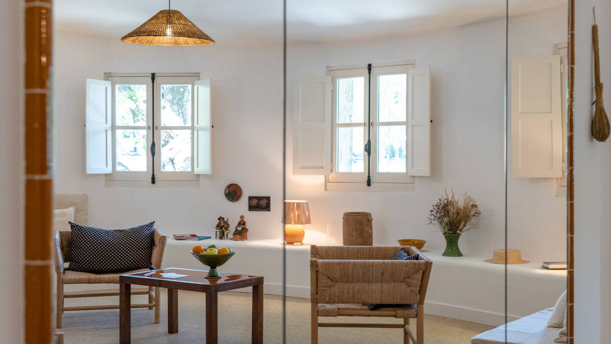 A reflection of the living space with chairs and table appears in the rectangular mirror.