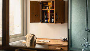 A reflection of the open cupboard is visible in the bathroom mirror above the sink.