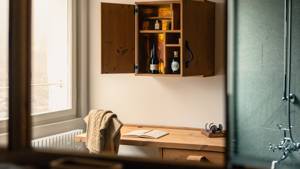 The reflection of an open cupboard is visible in the bathroom mirror above the sink.