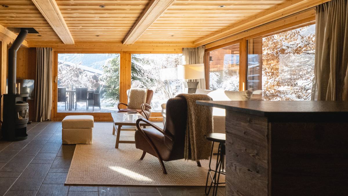 An organized living space features a cozy sofa set, a unique coffee table, and a mountain view.