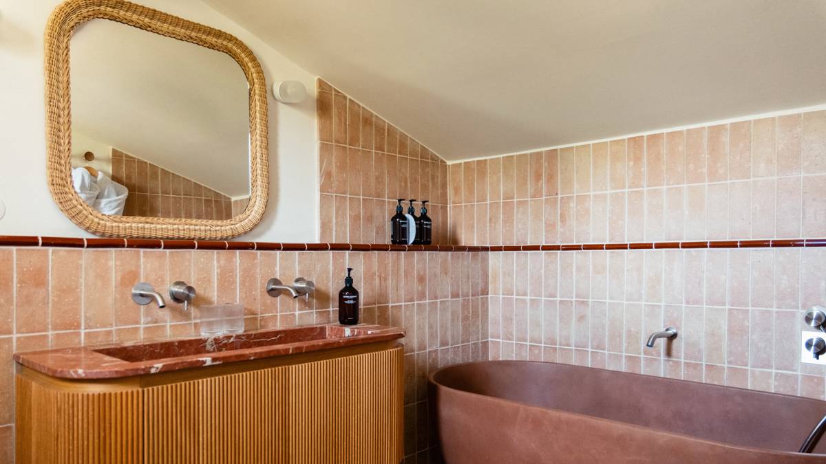 A captured photo of the bathroom shows a mounted mirror and a bathtub on the right.