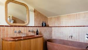 A captured photo of the bathroom shows a mounted mirror and a bathtub on the right.