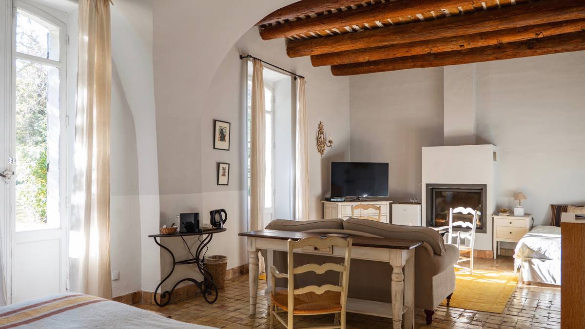 A tidy living space features a cozy sofa near the fireplace and a TV beside.