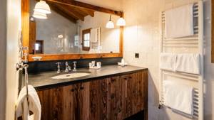 A clicked photo of a bathroom shows properly organized bathing essentials near the washbasin countertop.