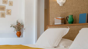 Some decorative items are placed on the bed’s headboard, with portraits mounted on the left wall.