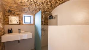 A clicked photo of the bathroom features arranged bathing essentials and a shower in the corner.