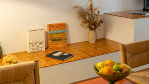 Some notebooks are placed on the low countertop along with a flower vase.