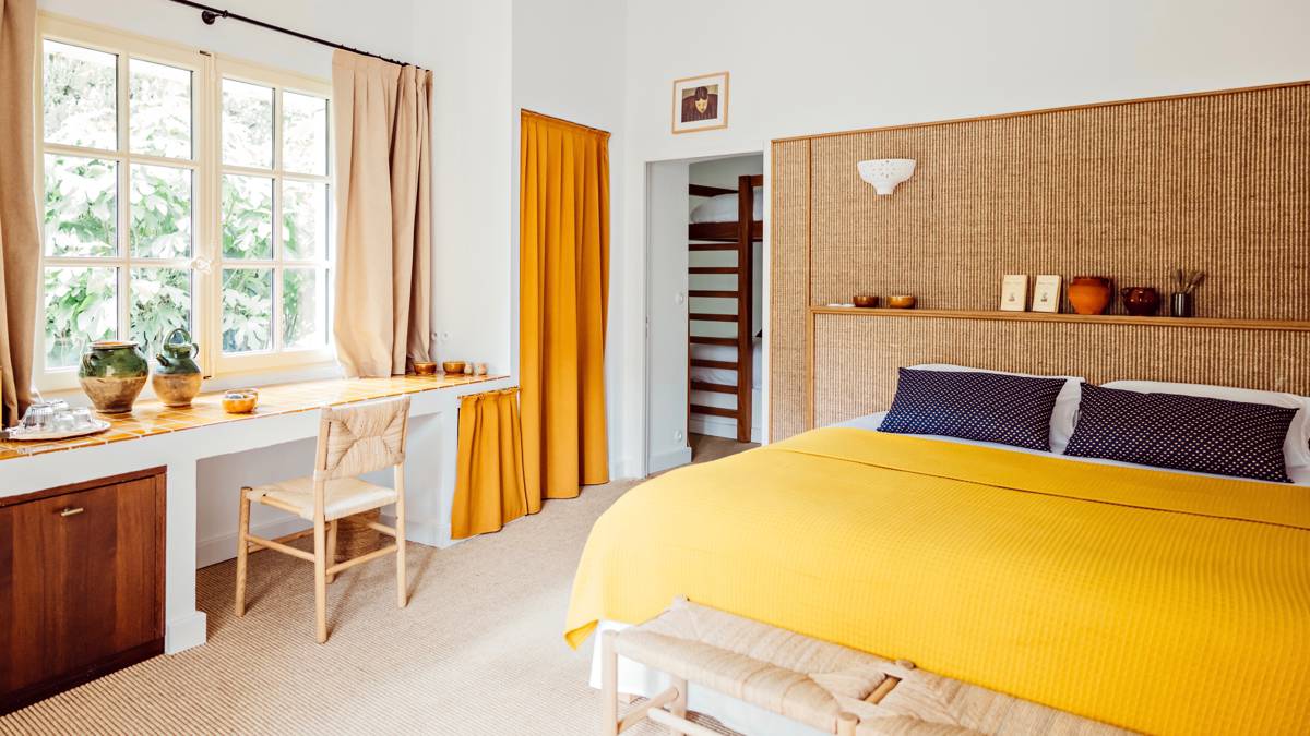 A well-organized bedroom features a cozy bed, a chair, and a table by the window.