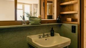 A large mirror is mounted above the washbasin in the bathroom, beautifully reflecting the space.