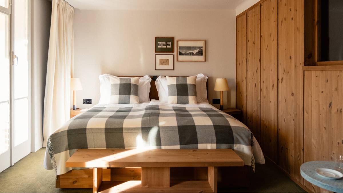 A well-organized bedroom showcases a cozy bed with two side tables and portraits above.