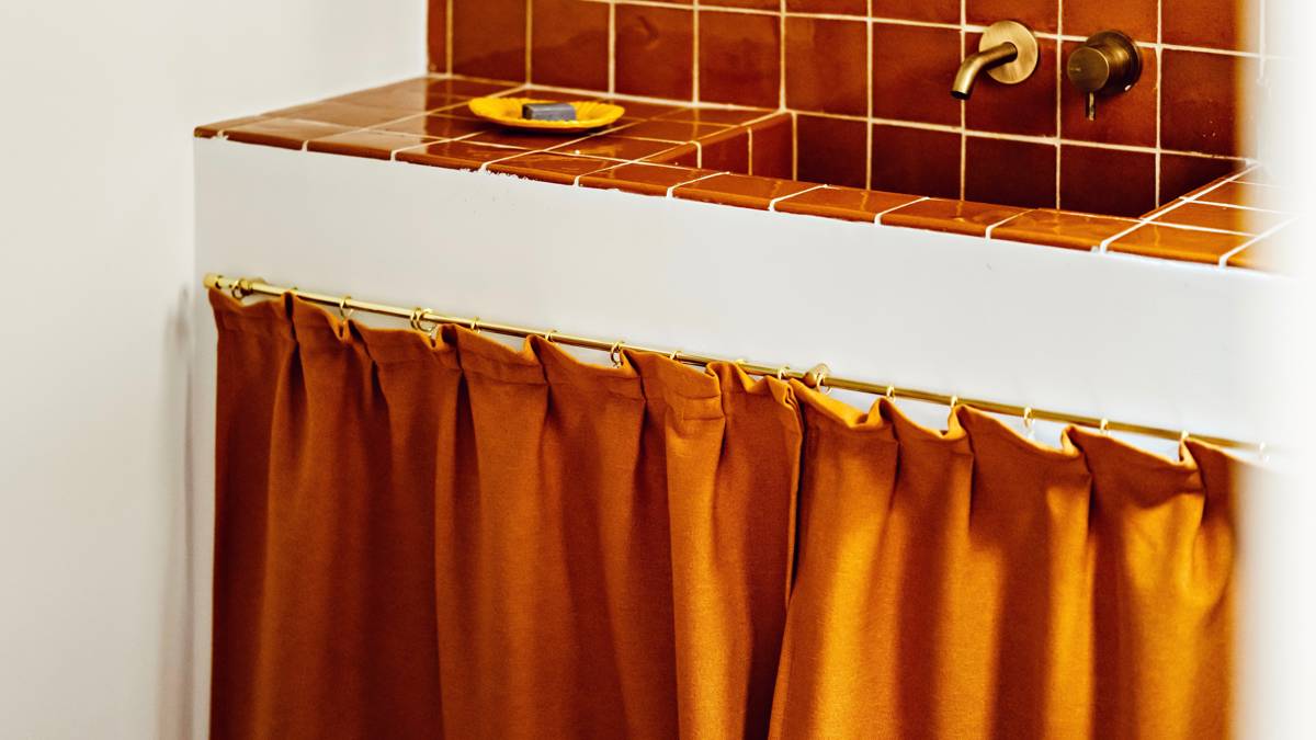 A clicked photo showcases an orange-colored washbasin countertop.