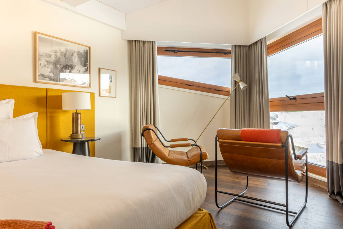 Ambiance chaleureuse de l'espace lit double dans la Suite Val Thorens.