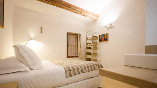 A tidy bedroom features a cozy bed, a corner frame, and front wall portrait.