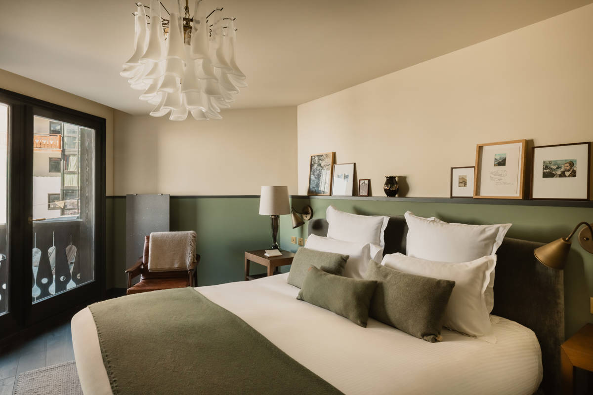 Chambre du Fitz Roy avec fauteuil en cuir, balcon et vue sur le village de Val Thorens