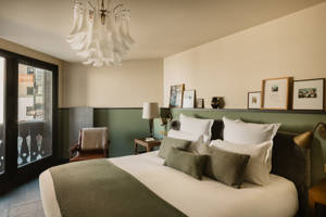 Chambre du Fitz Roy avec fauteuil en cuir, balcon et vue sur le village de Val Thorens