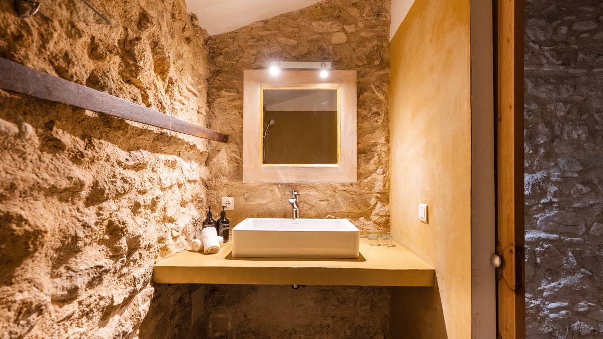 A photo of the bathroom features a mirror mounted above the washbasin with sparkling lights.
