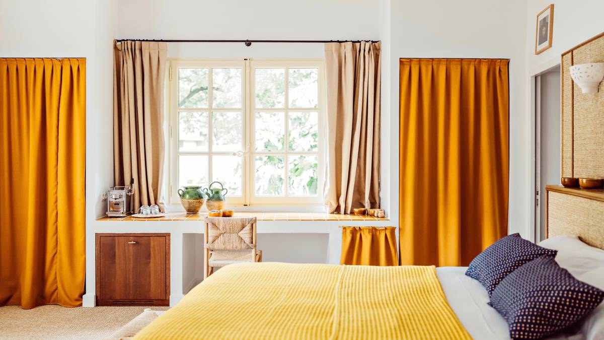 A well-organized bedroom features a cozy bed and a chair by the table near the window.