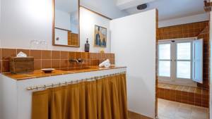 A clicked photo of the bathroom displays a long mirror mounted above the washbasin.