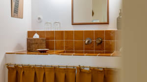 A clicked photo beautifully showcases an orange-colored washbasin countertop with a sleek finish.