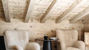 Two feather-touch sofa sets accompany a black coffee table holding a kettle, cup plate, and notebook.