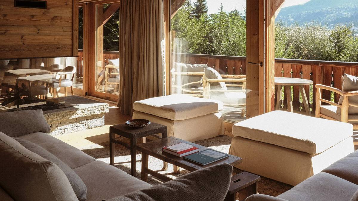 An organized living space features a cozy sofa set, unique coffee table, and mountain view.