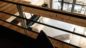 A photo captured from upstairs shows a dark green, cozy bed below.
