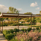 Covered outdoor wooden deck in a landscaped garden at Capelongue