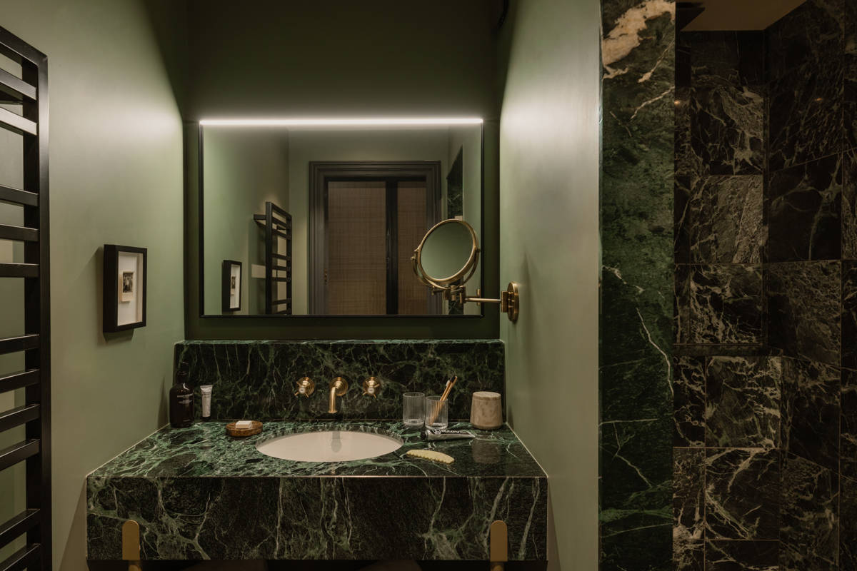 Salle de bains du Fitz Roy à Val Thorens, vasque en marbre vert, robinetterie laiton et miroir rétroéclairé