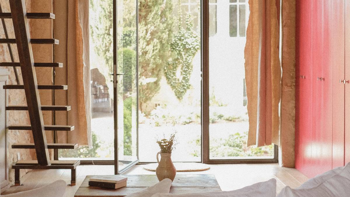 A wonderful view of the lush green lawn is visible through the room’s glass door.