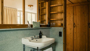 A large mirror is mounted above the washbasin in the bathroom, reflecting the space.