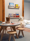 Kinderecke mit niedrigem Tisch, Hockern, Büchern und weißem Teddybär