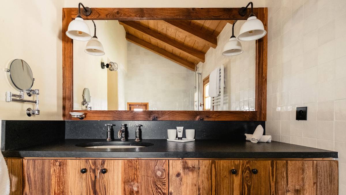 Modern bathroom with a freestanding bathtub, double sinks, large mirror, and soft natural lighting.