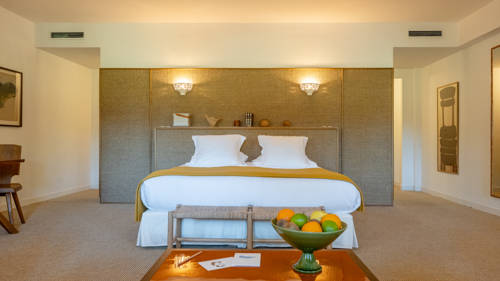 A well-organized bedroom features a cozy bed and a table in front holding a fruit basket.